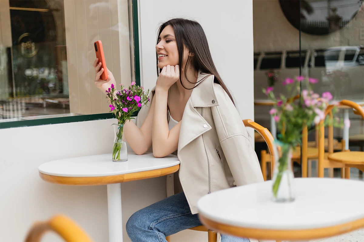 A woman looking at her phone at a cafe table