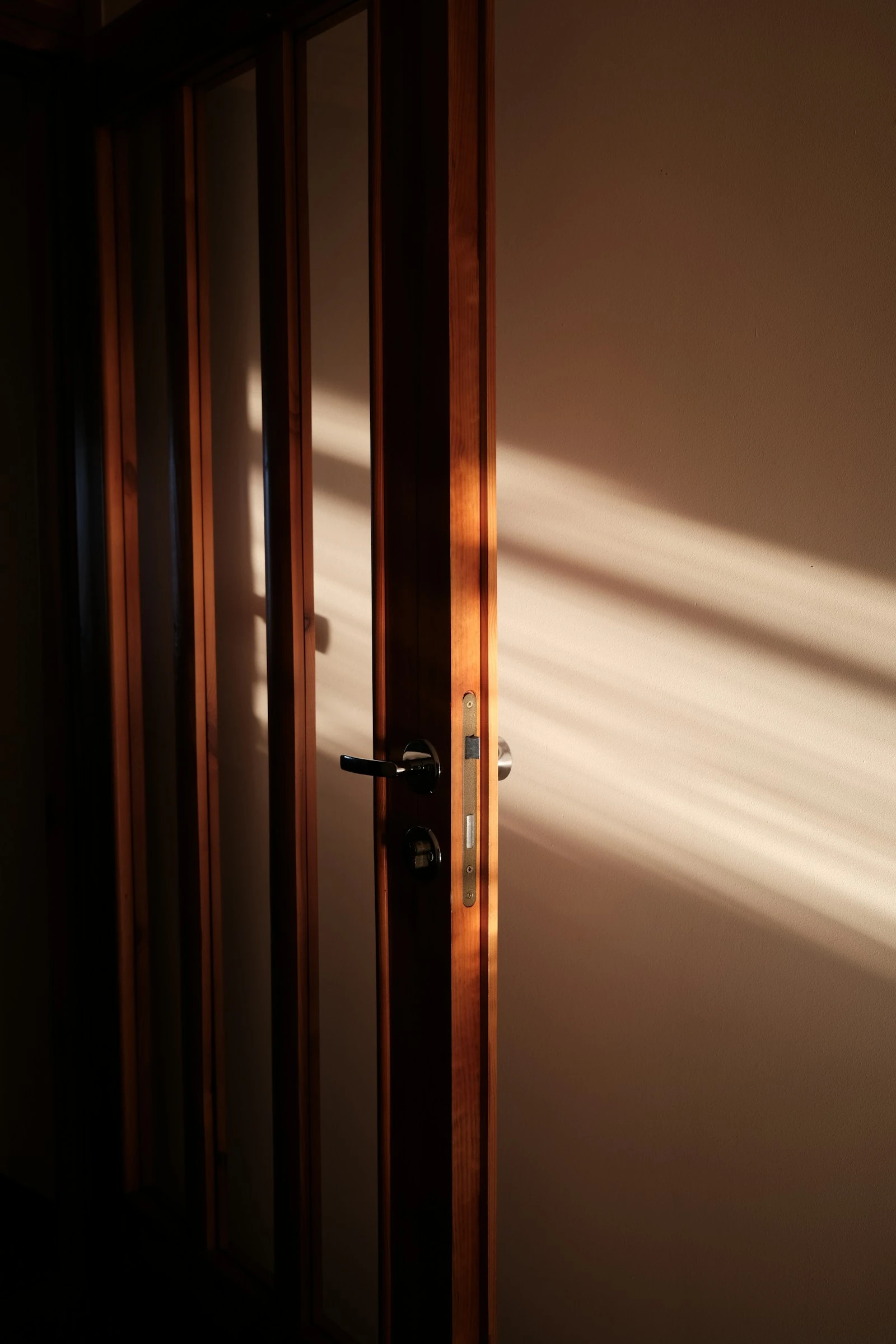 Wooden door slightly open to warm light
