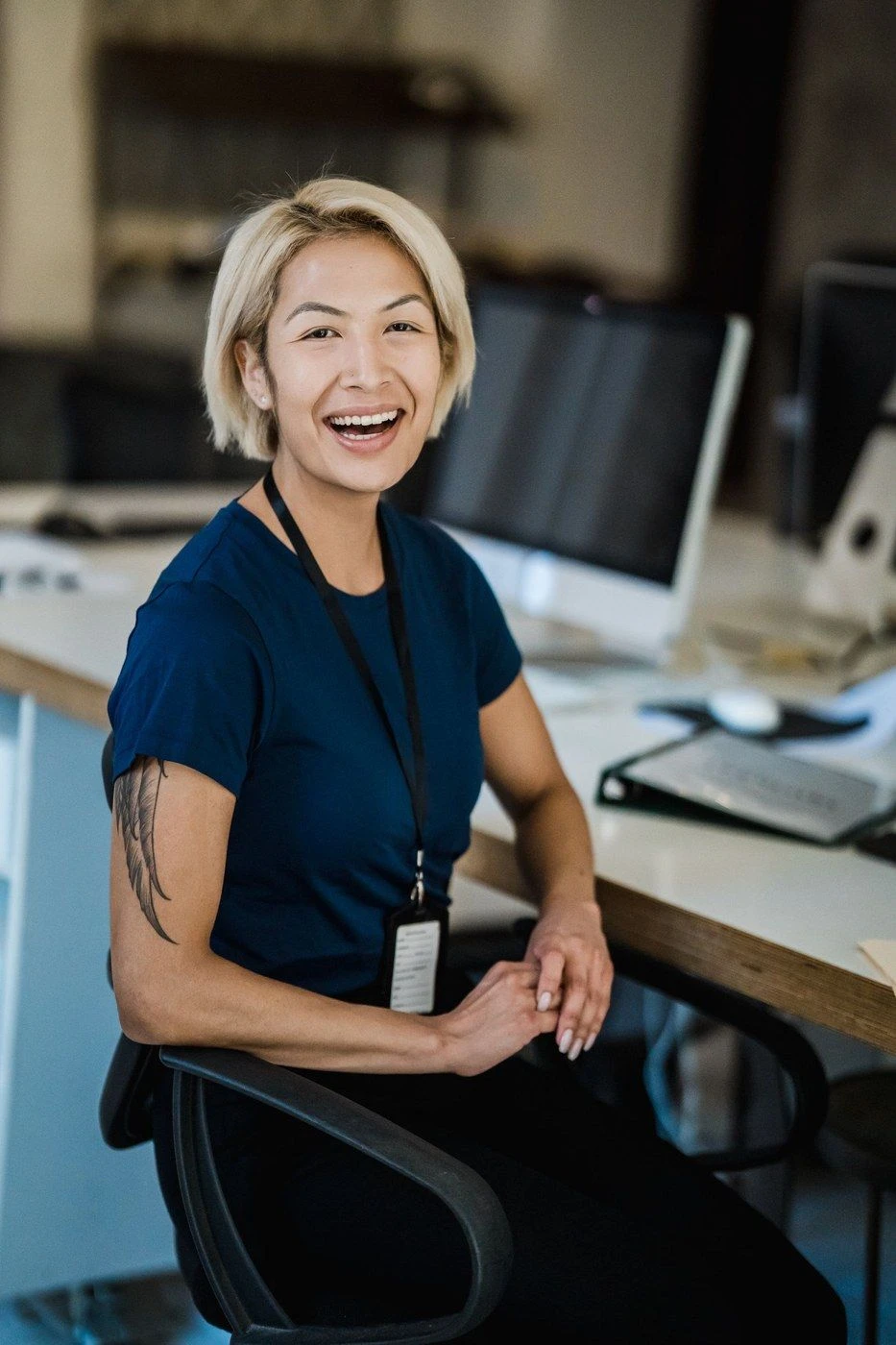A woman laughing at a desk in a bright office