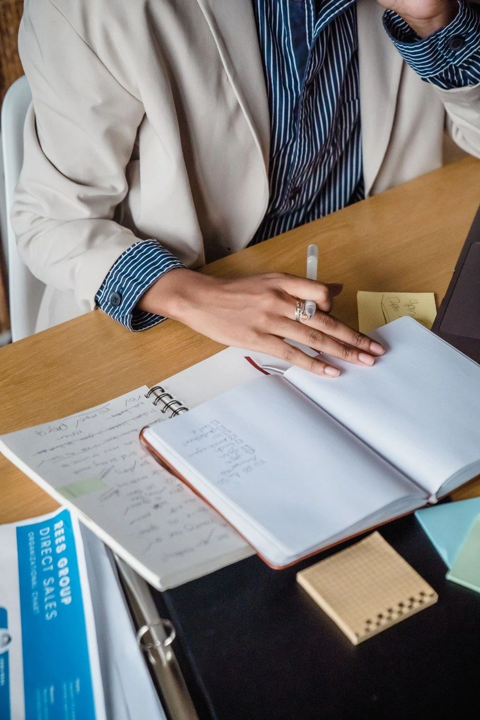 Hands writing in a notebook at a desk