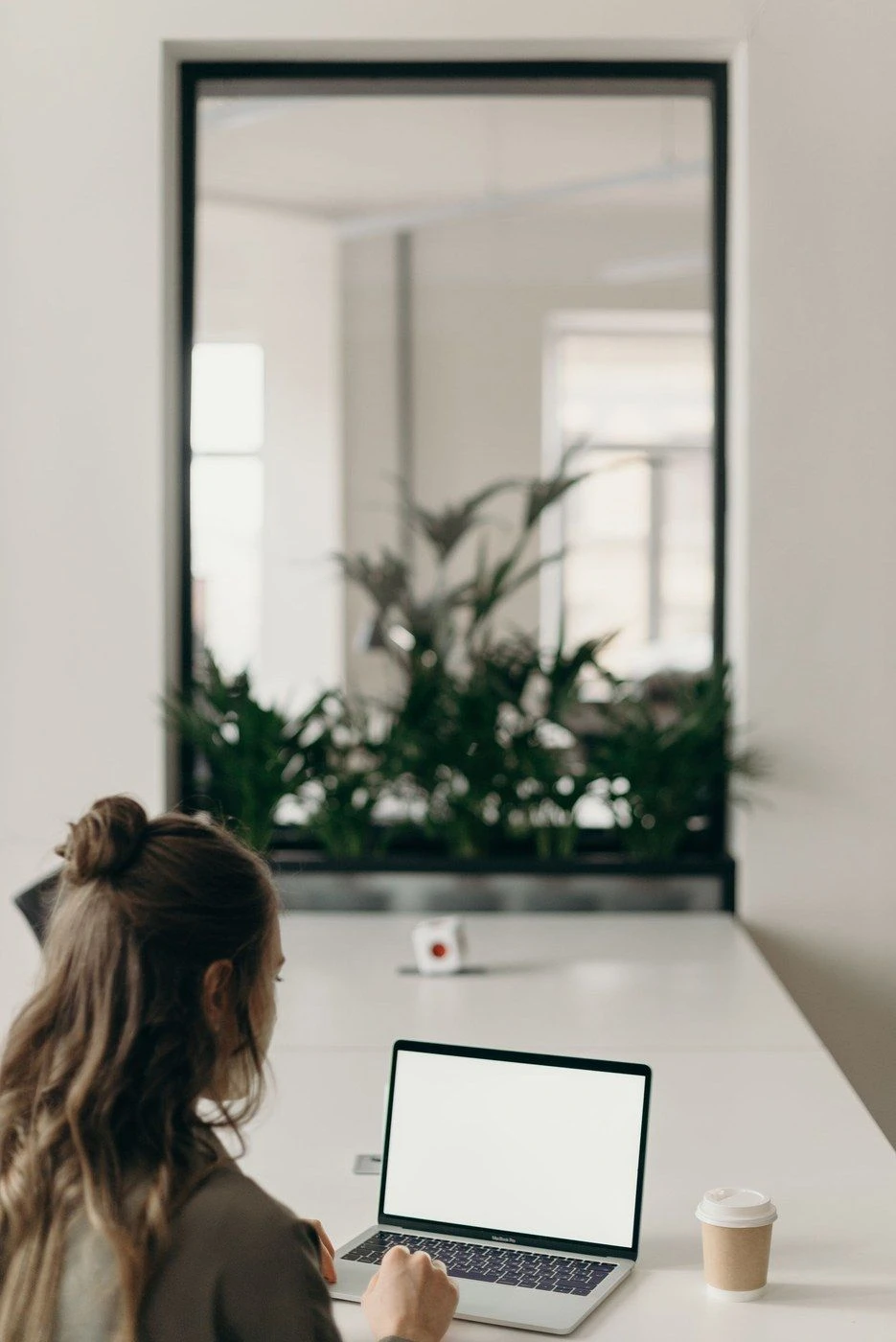 A woman at a desk among plants