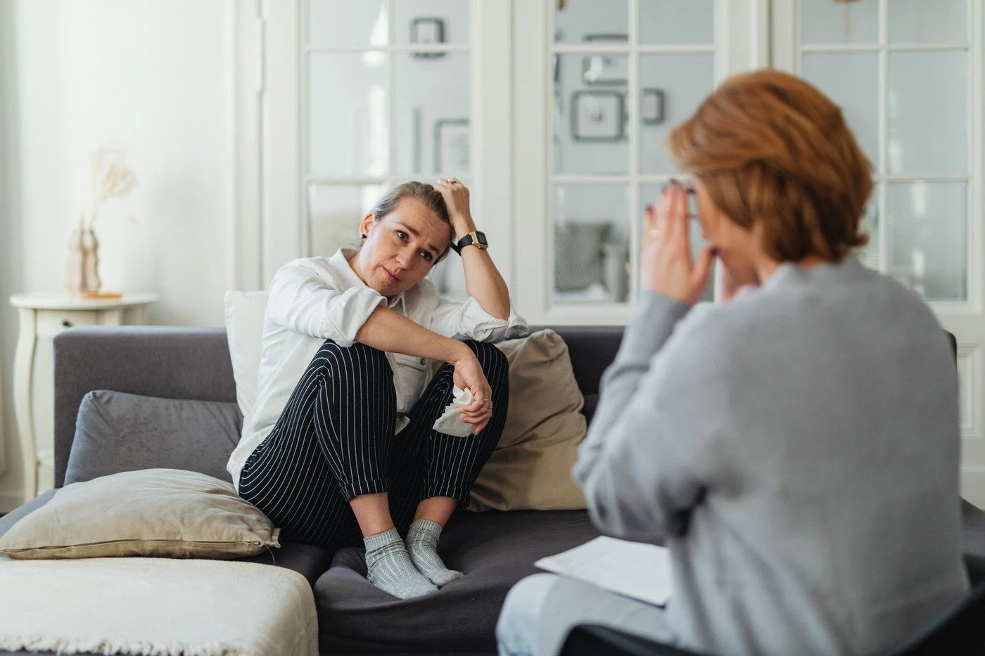 A psychologist and a client talking on a sofa
