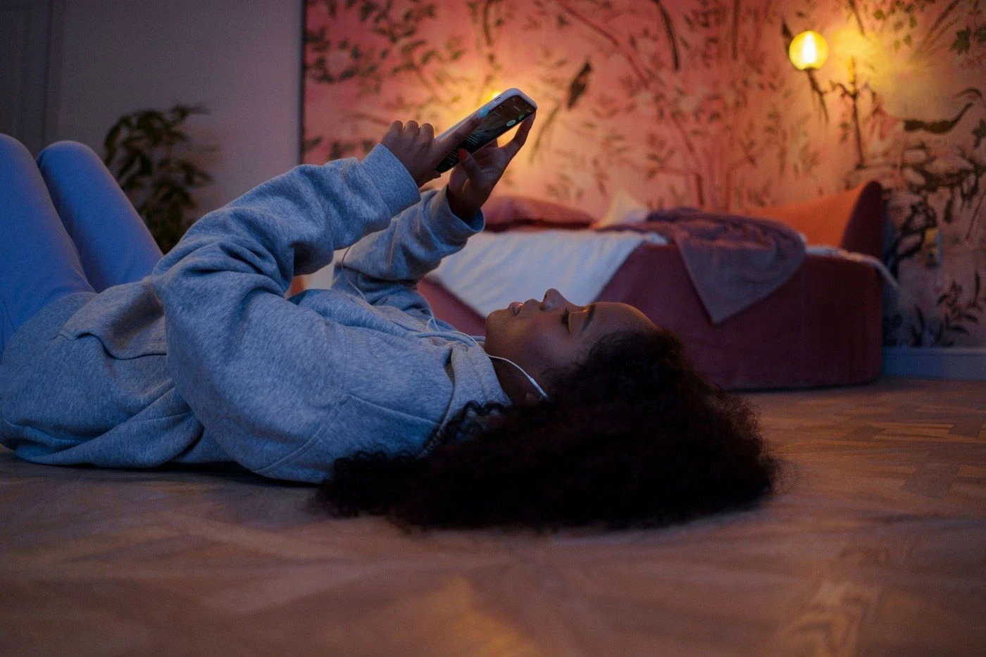 A woman lying down looking at her phone