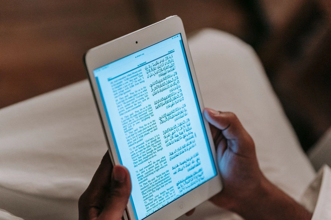 A tablet in a hand, showing a page of text