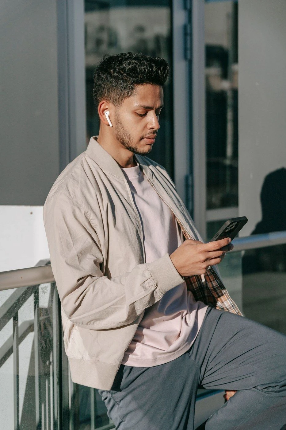 A man on a balcony reading his phone