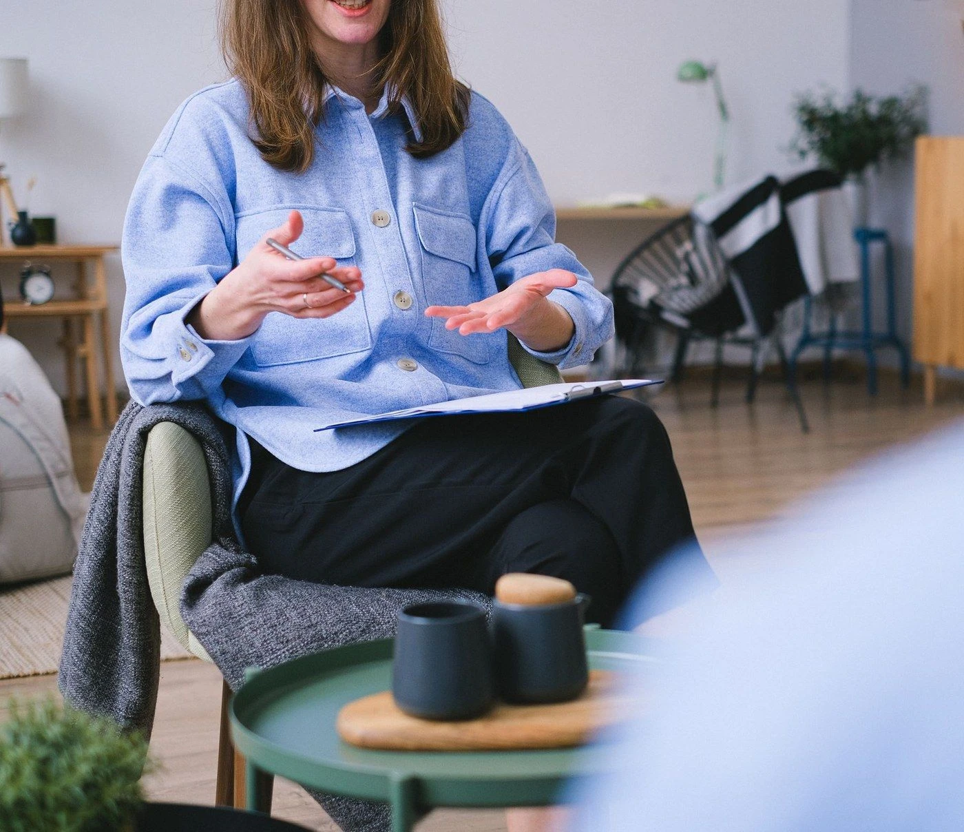A therapist gesturing while talking with a client
