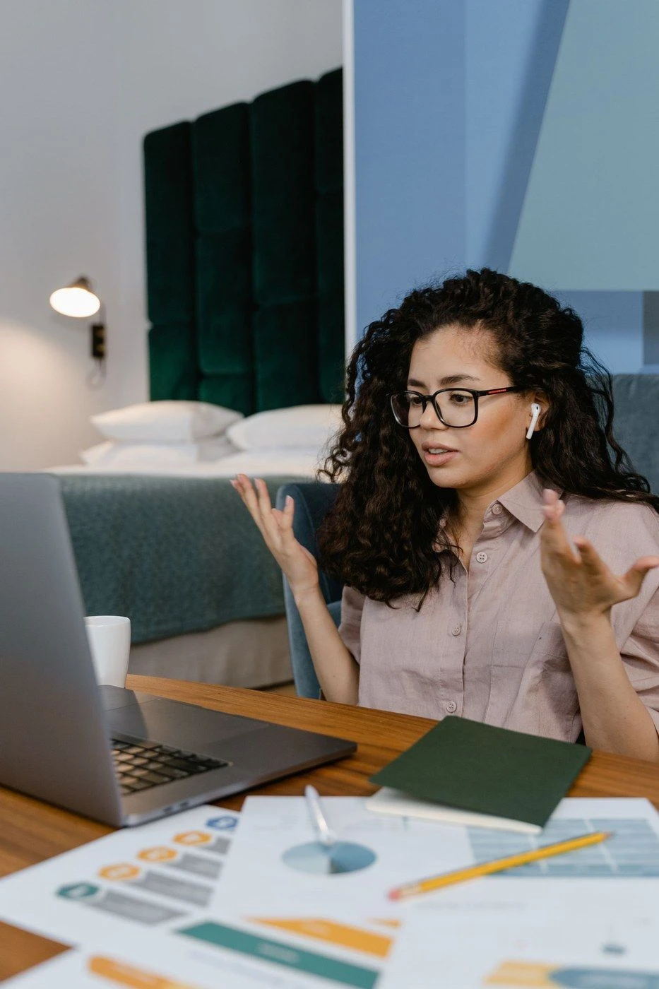 A woman gesturing while talking to her laptop