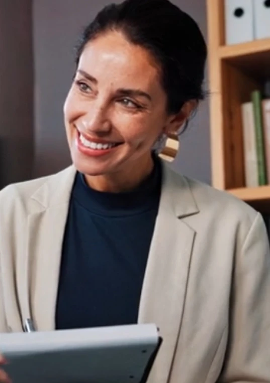 A solo practitioner holding a tablet in her office